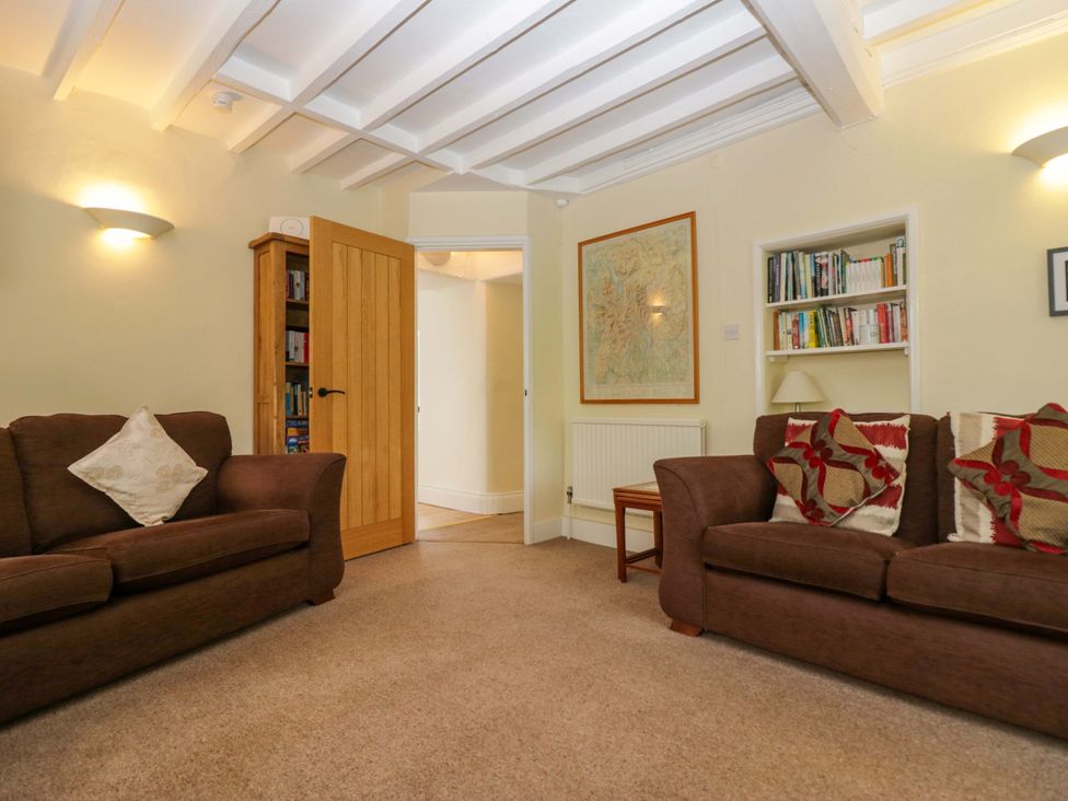 A living room with sofas and bookshelves at Hollens Cottage in Grasmere