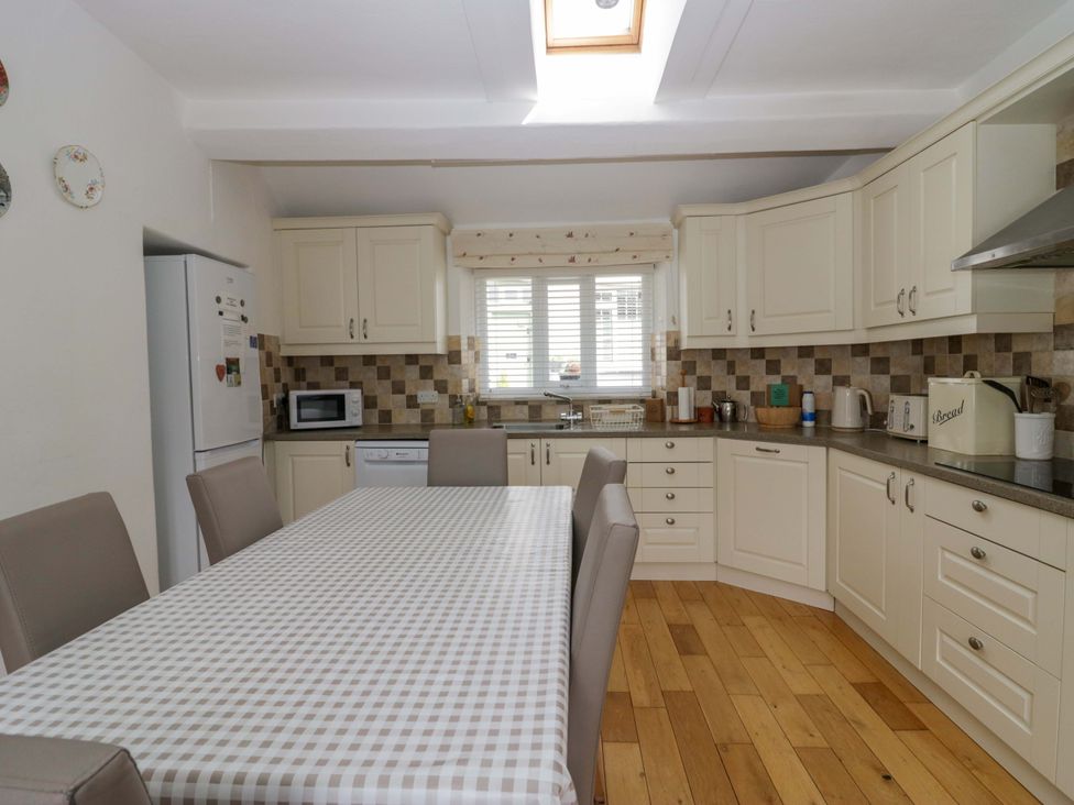 A kitchen with a dining table and appliances at Hollens Cottage in Grasmere