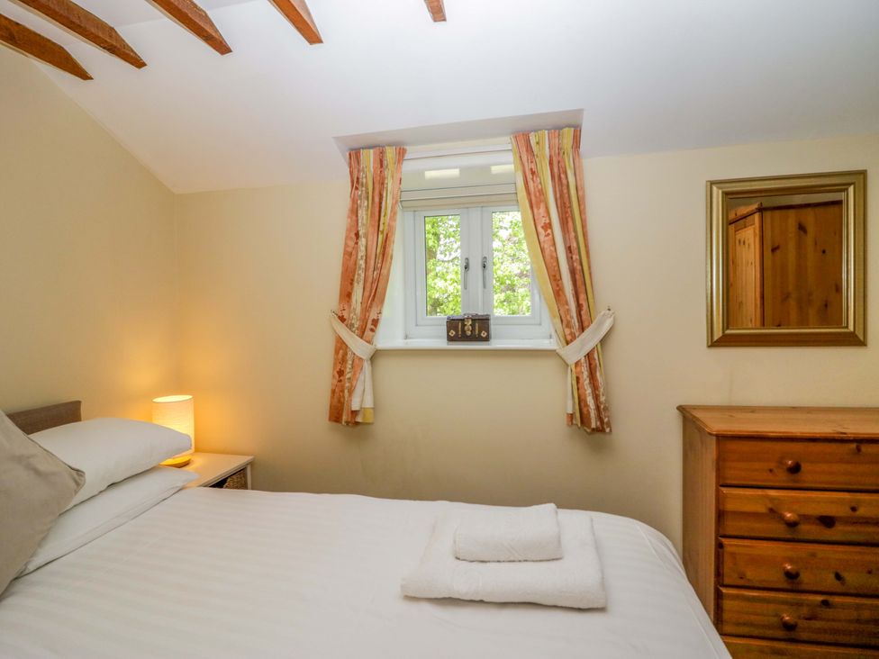 A bedroom with a bed and a window at Hollens Cottage in Grasmere