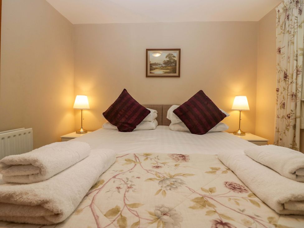 A bedroom with a bed and bedside tables at Hollens Cottage in Grasmere