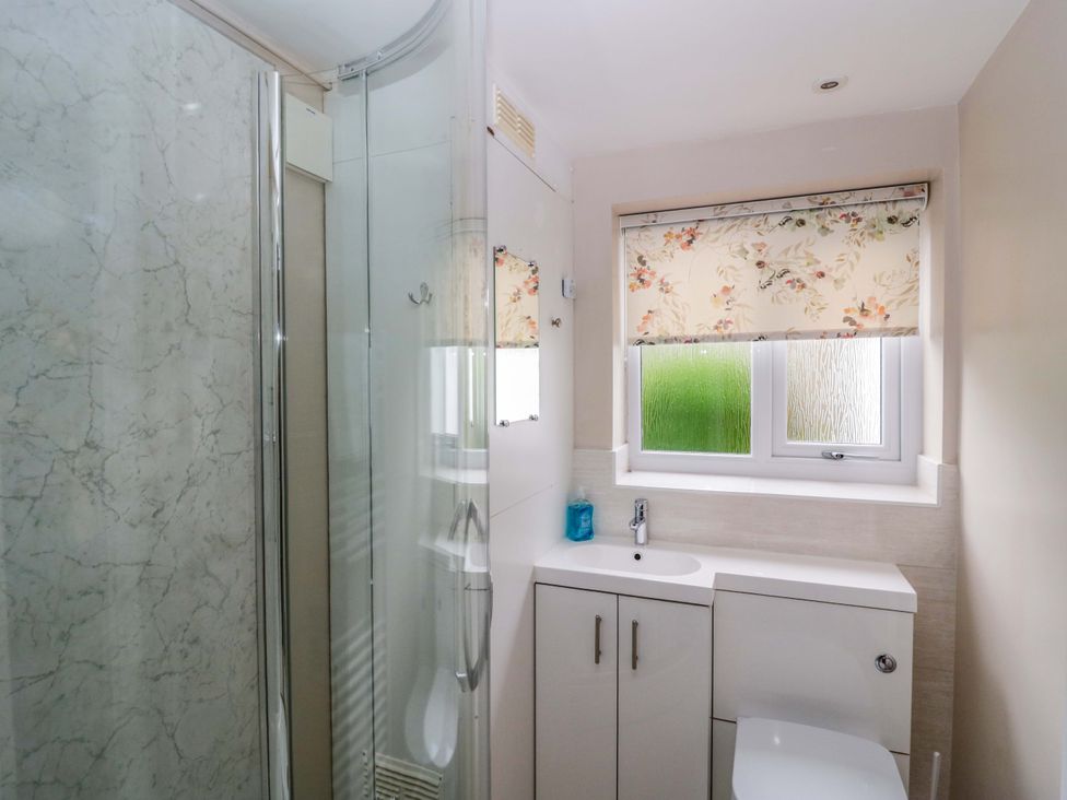 A bathroom with a shower and sink at Hollens Cottage Grasmere