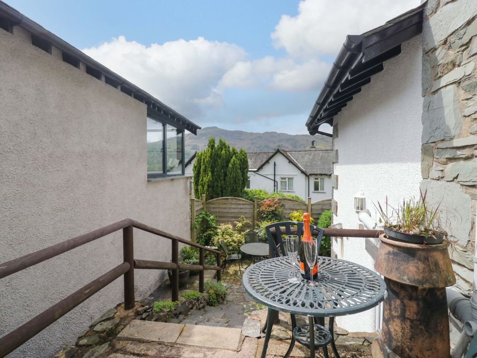 A garden with a table and chairs at Hollens Cottage in Grasmere