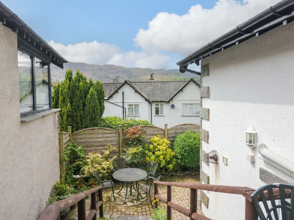 A garden with a table and chairs at Hollens Cottage in Grasmere