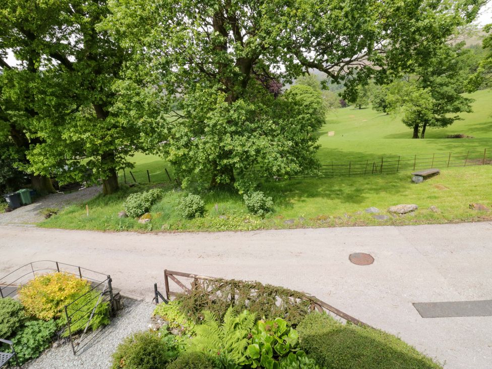 An outdoor view with trees and grass at Hollens Cottage in Grasmere