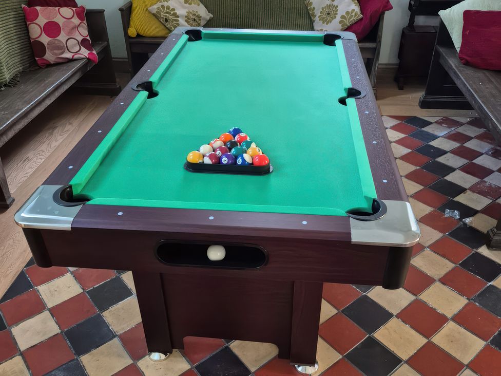 A pool table with billiard balls arranged in a game rack at Church Llygad Y Dyffryn in Sarnau near Brynhoffnant