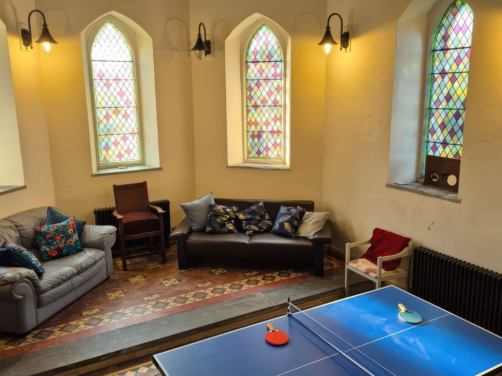 A recreation room with seating and a ping pong table at Church Llygad Y Dyffryn Sarnau near Brynhoffnant