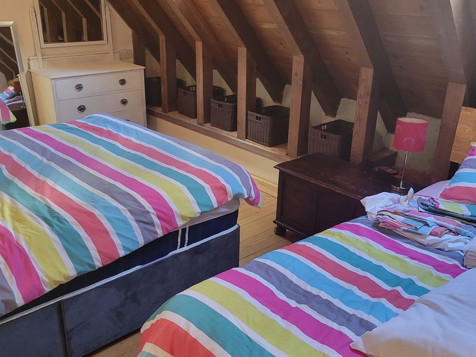 A bedroom with two beds and a dresser at Church Llygad Y Dyffryn Sarnau near Brynhoffnant