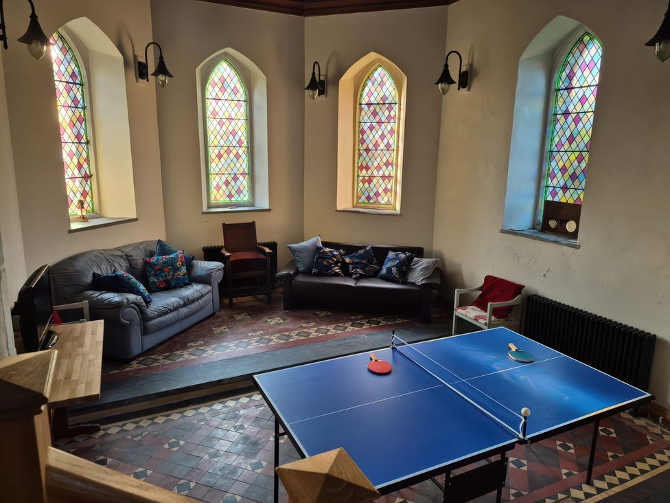 A game room with a table tennis table and sofas at Church Llygad Y Dyffryn in Sarnau near Brynhoffnant