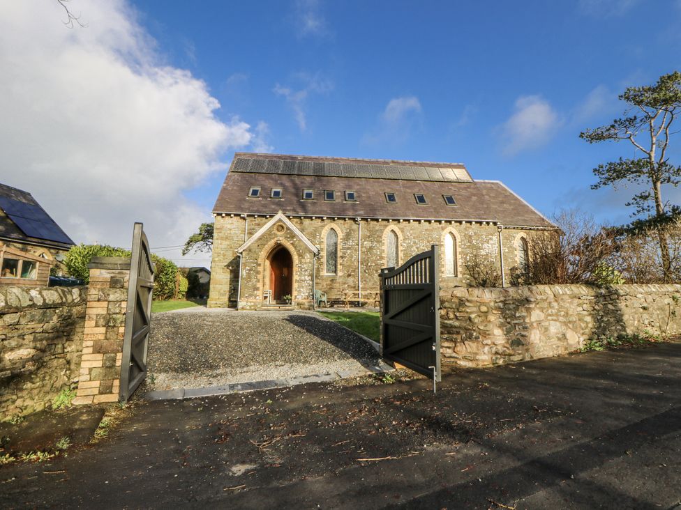 A stone building with a gravel driveway at Church Llygad Y Dyffryn in Sarnau near Brynhoffnant