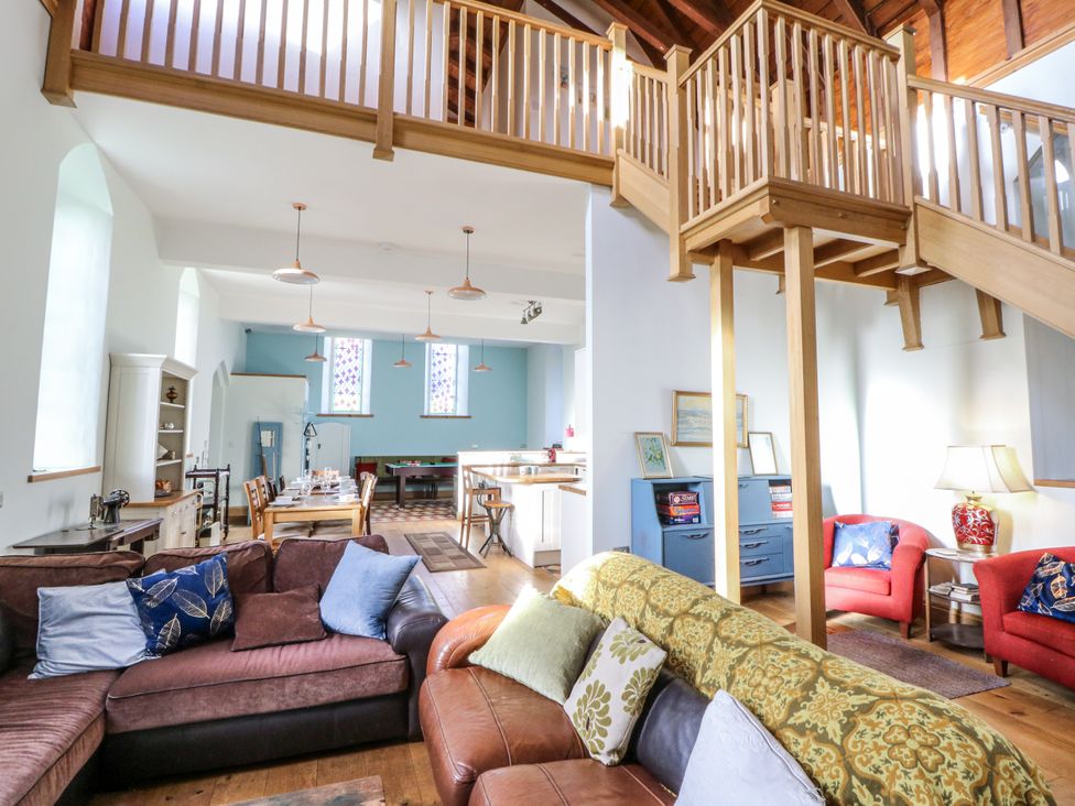 A living room with a sofa and dining area at Church Llygad Y Dyffryn in Sarnau near Brynhoffnant