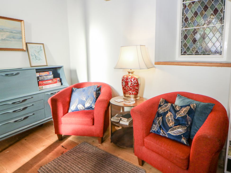 A living room with two red armchairs and a lamp at Church Llygad Y Dyffryn Sarnau near Brynhoffnant