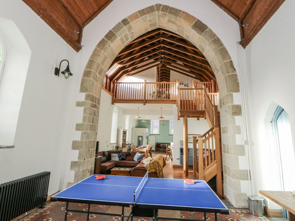 A living room with a ping pong table and seating area at Church Llygad Y Dyffryn, Sarnau near Brynhoffnant