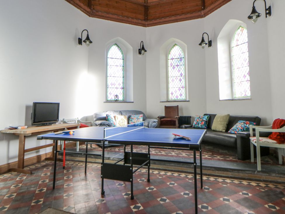 A living room with a ping pong table and a television at Church Llygad Y Dyffryn, Sarnau near Brynhoffnant