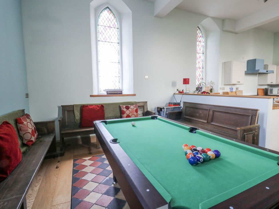 A recreation room with a pool table and benches at Church Llygad Y Dyffryn Sarnau near Brynhoffnant