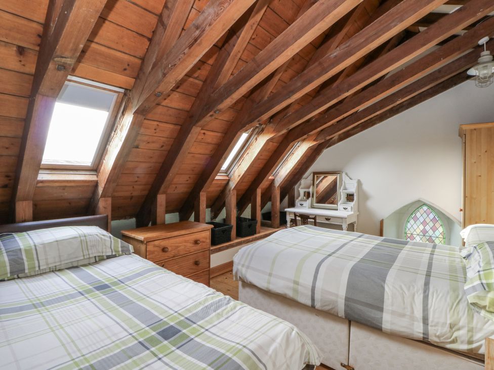 A bedroom with two beds and a dressing table at Church Llygad Y Dyffryn in Sarnau near Brynhoffnant
