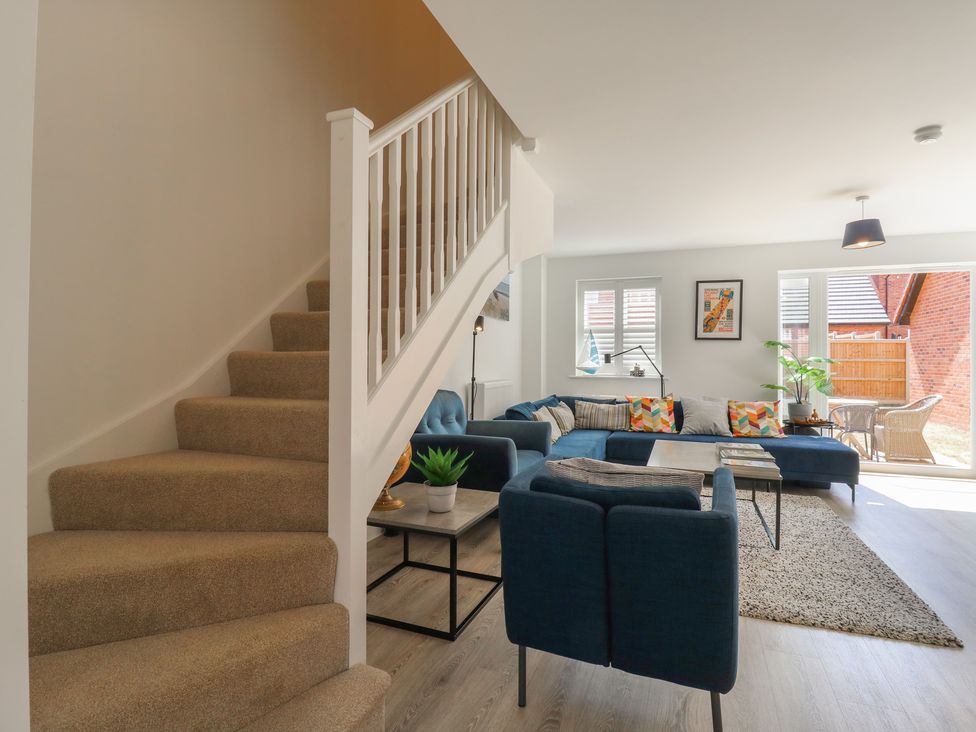 A living room with a staircase and a sofa at Inishnee House in Shotley Gate