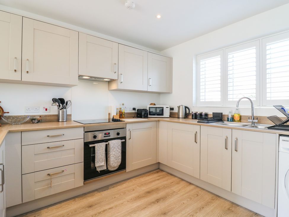 A kitchen with cabinets, sink, oven, microwave, and kettle at Inishnee House Shotley Gate