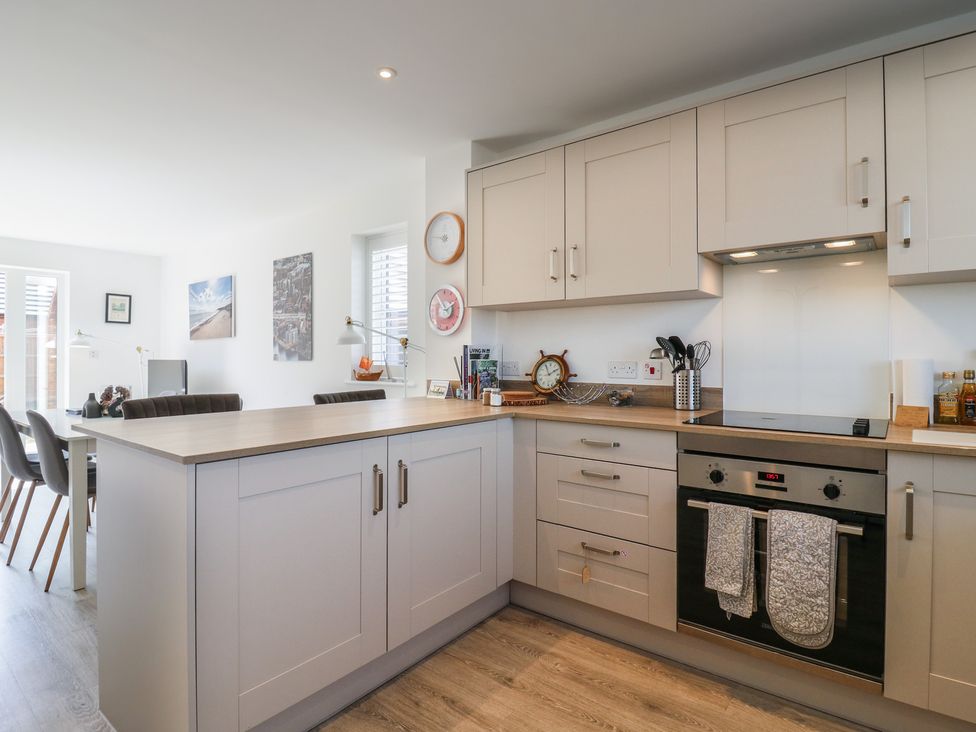 A kitchen with cabinets, oven, and seating area at Inishnee House in Shotley Gate