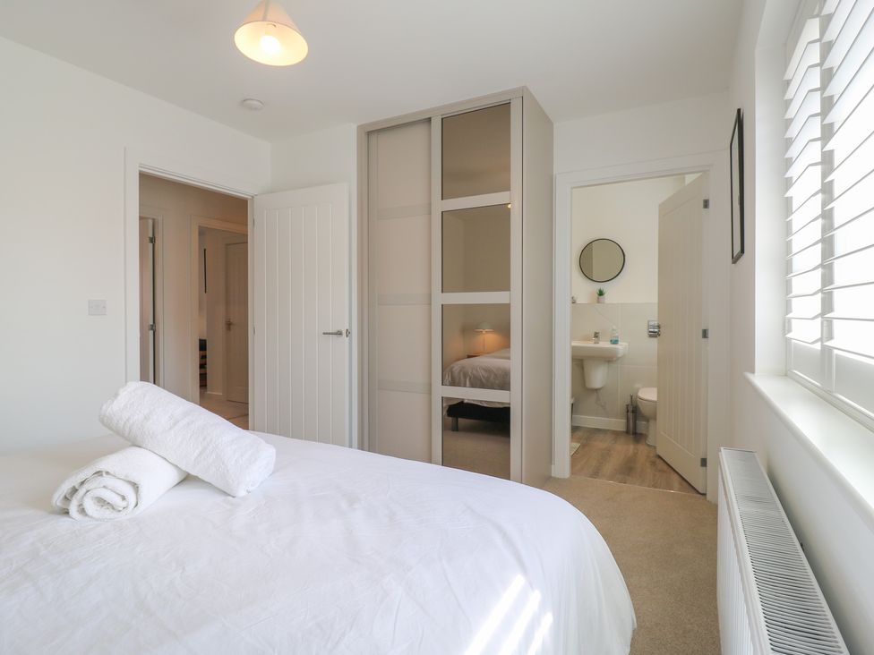 A bedroom with towels on a bed at Inishnee House in Shotley Gate