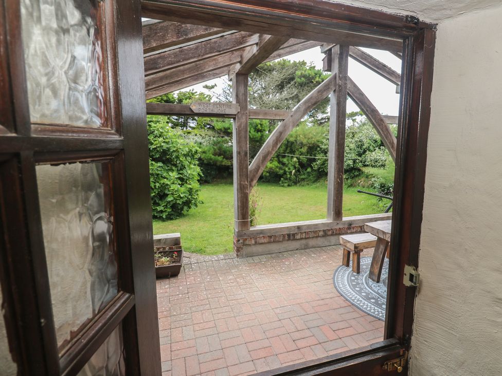 A view of a garden with a table and chairs at Horseshoe Cottage near Holywell Bay