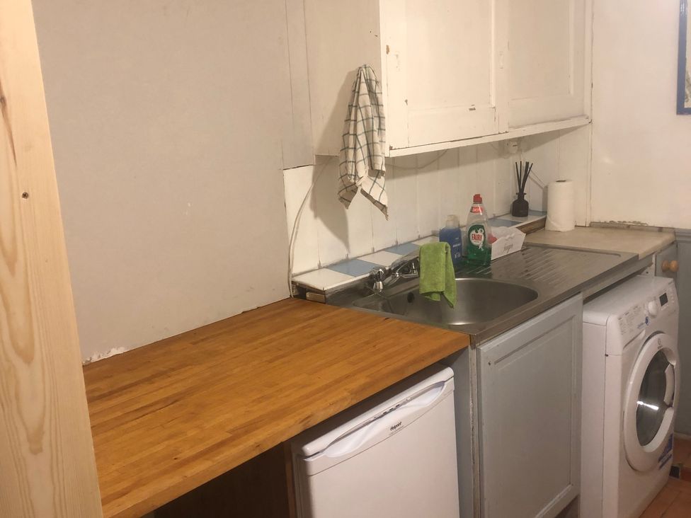 A kitchen with a sink and washing machine at Pittencleroch Mill Crieff