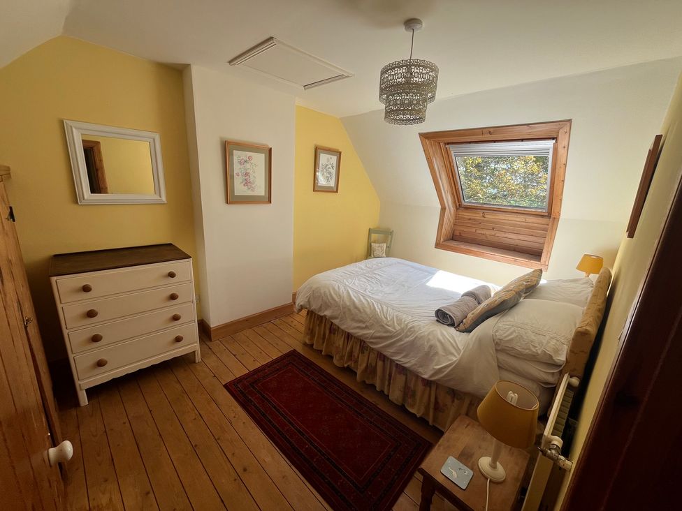 A bedroom with a bed, lamps, and decorative artwork at Pittencleroch Mill Crieff