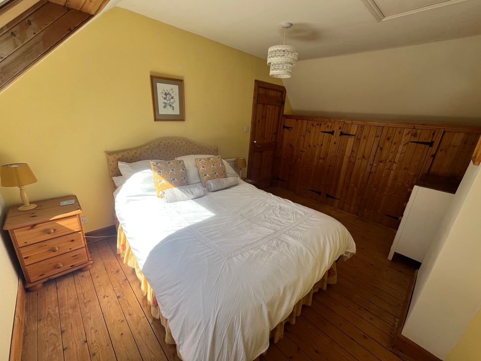 A bedroom with a bed and nightstand at Pittencleroch Mill in Crieff