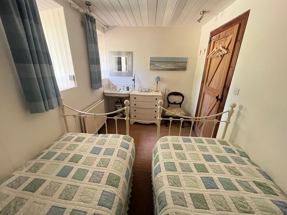 A bedroom with two beds and a dressing table at Pittencleroch Mill in Crieff