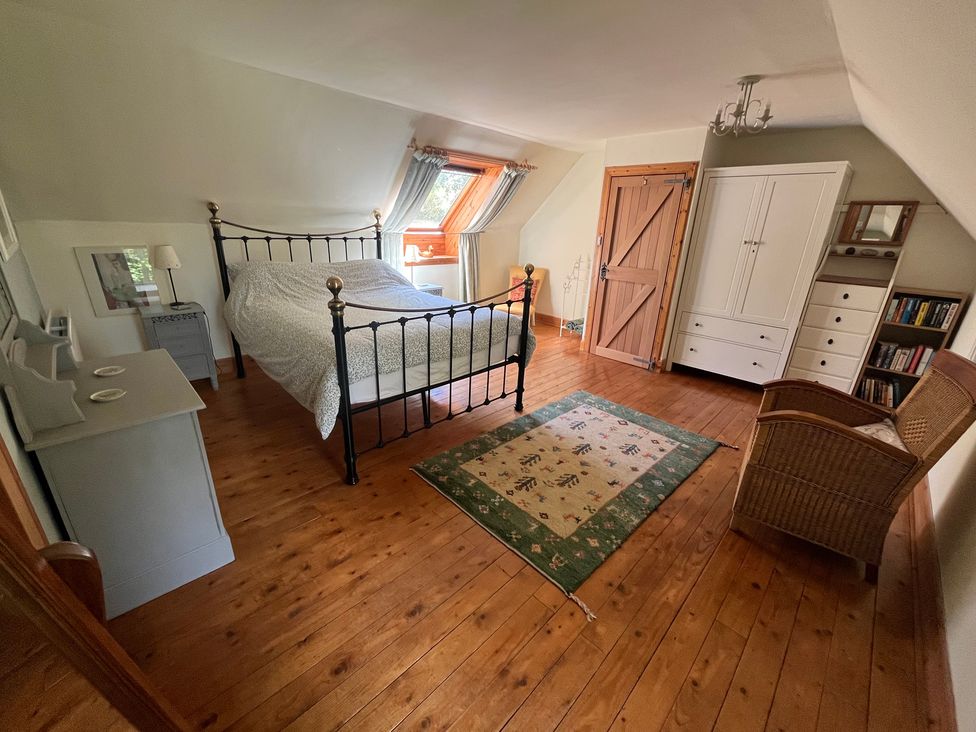 A bedroom with a bed and wardrobe at Pittencleroch Mill in Crieff