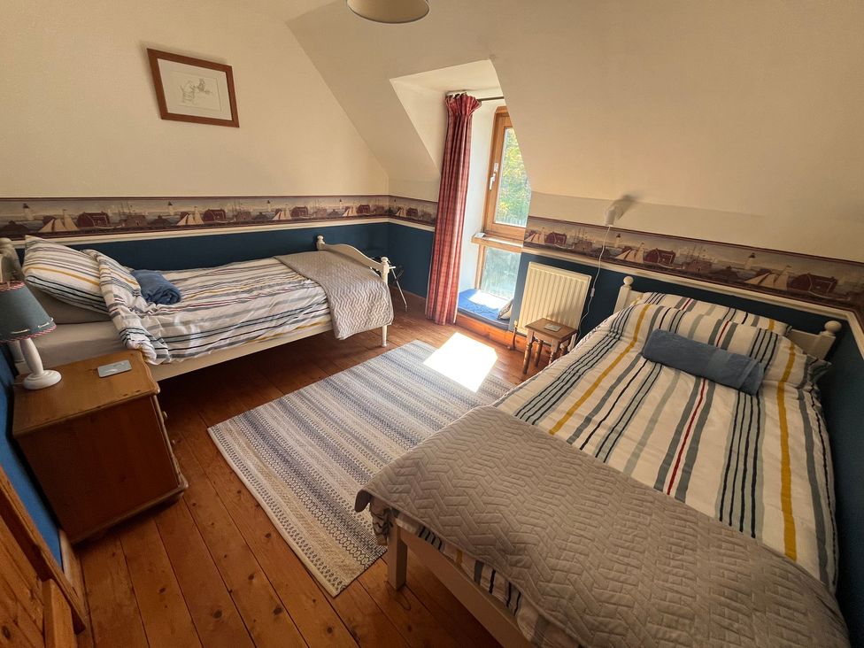 A bedroom with two beds and a window at Pittencleroch Mill in Crieff