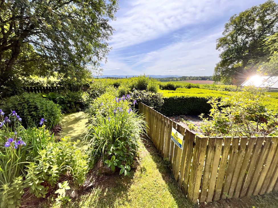 A garden with flowers and a wooden fence at Pittencleroch Mill in Crieff
