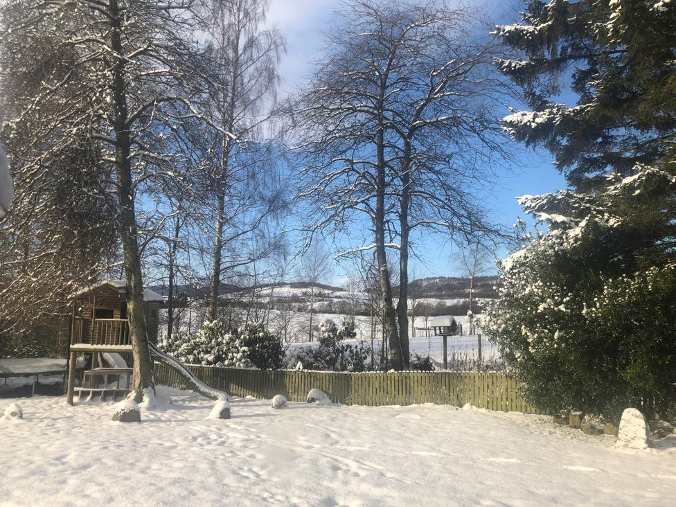 A garden with a playhouse and slide covered in snow at Pittencleroch Mill in Crieff