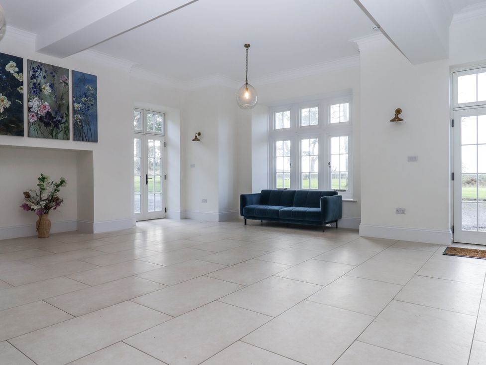 A living room with a sofa and wall art at Alston Hall Battisborough Cross