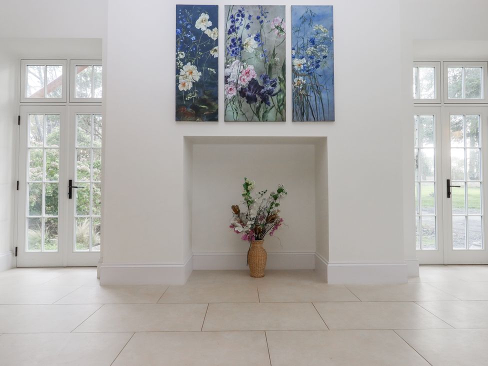 A living room with artwork and a flower arrangement at Alston Hall Battisborough Cross