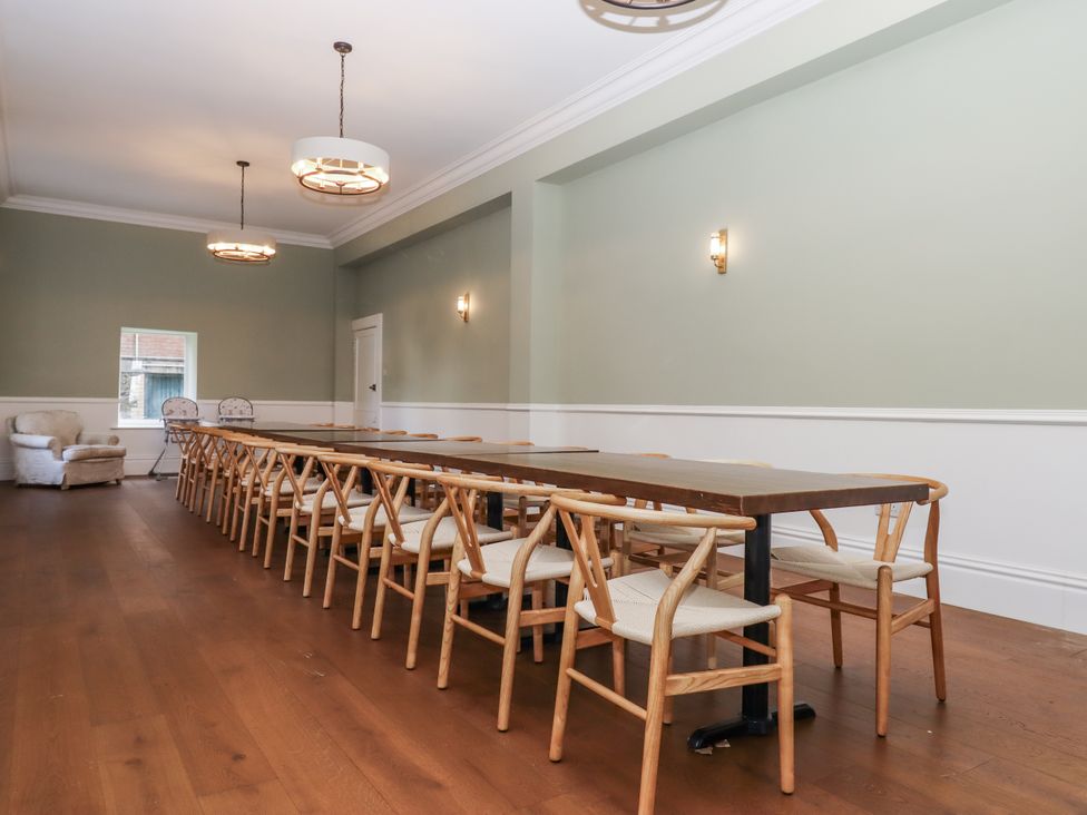 A dining room with a long table and chairs at Alston Hall Battisborough Cross