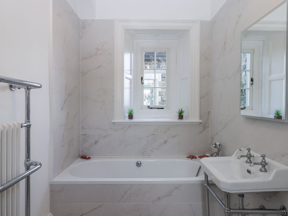 A bathroom with a bathtub and sink at Alston Hall Battisborough Cross
