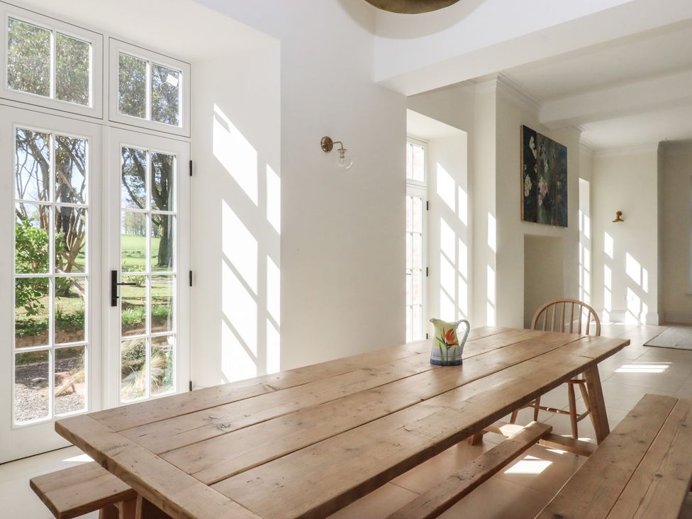 A dining room with a wooden table and chairs at Alston Hall near Mothecombe Beach