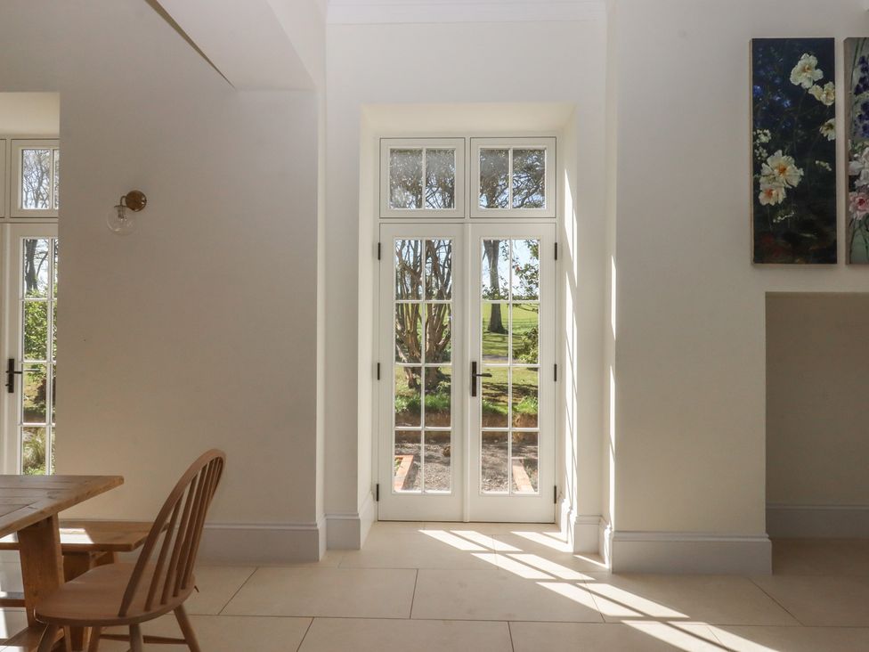 A dining room with a table and chairs at Alston Hall near Mothecombe Beach