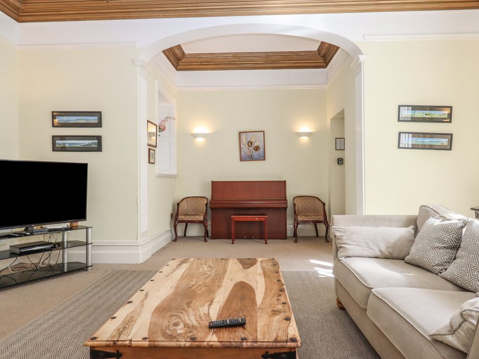 A living room with a television and a coffee table at Alston Hall near Mothecombe Beach