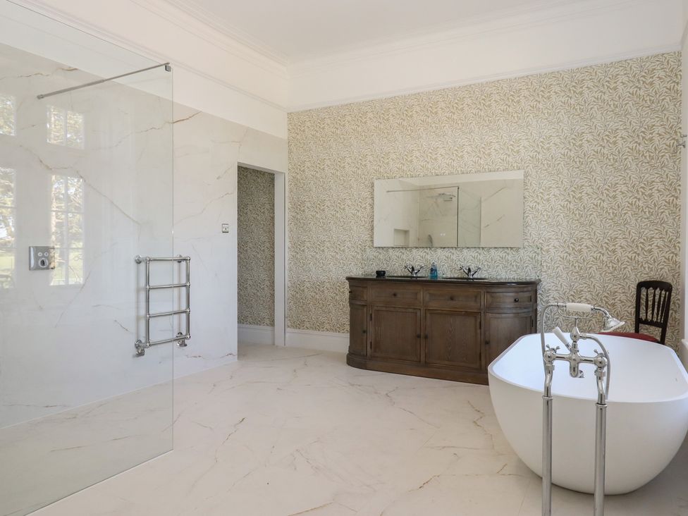 A bathroom with a bathtub and shower at Alston Hall near Mothecombe Beach