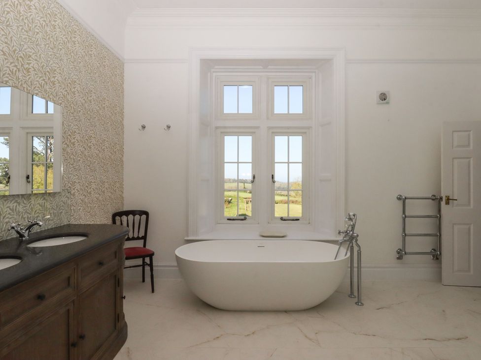 A bathroom with a bathtub and sink at Alston Hall near Mothecombe Beach