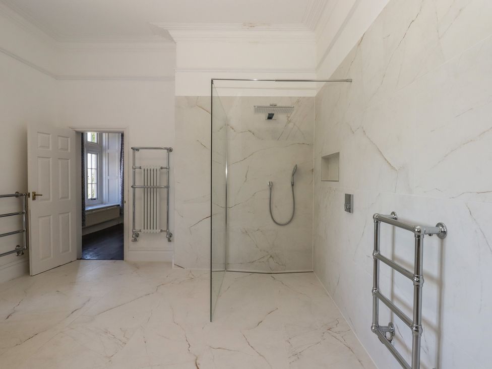 A bathroom with a shower and radiator at Alston Hall near Mothecombe Beach