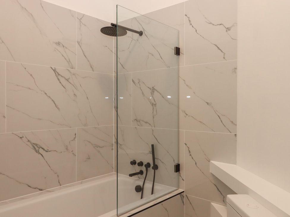 A bathroom with a bathtub and shower at Alston Hall near Mothecombe Beach