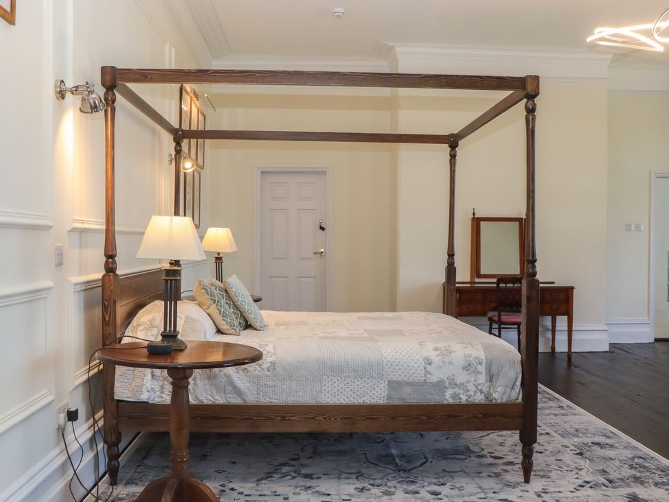 A bedroom with a canopy bed and furniture at Alston Hall near Mothecombe Beach