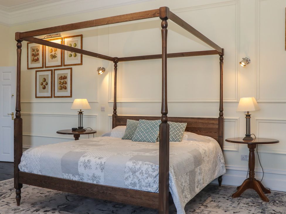 A bedroom with a four-poster bed and bedside tables at Alston Hall near Mothecombe Beach