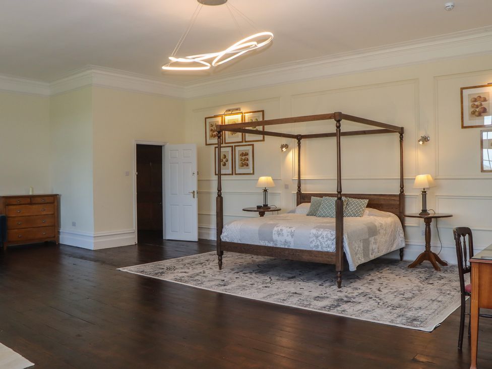 A bedroom with a four-poster bed and nightstand at Alston Hall near Mothecombe Beach