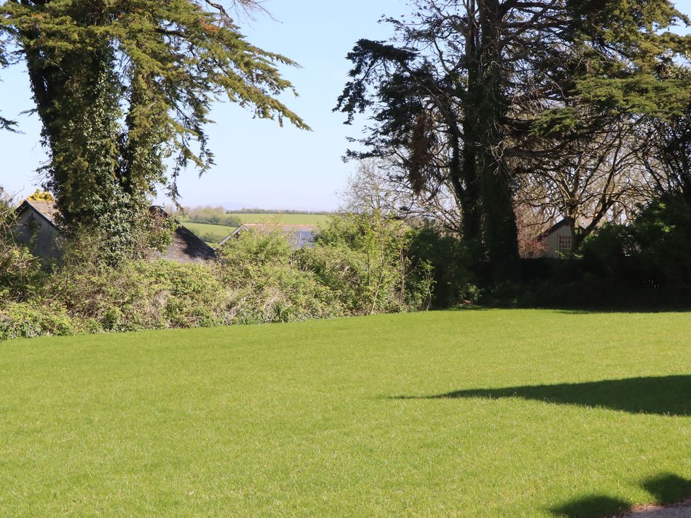 A garden with grass and trees at Alston Hall near Mothecombe Beach