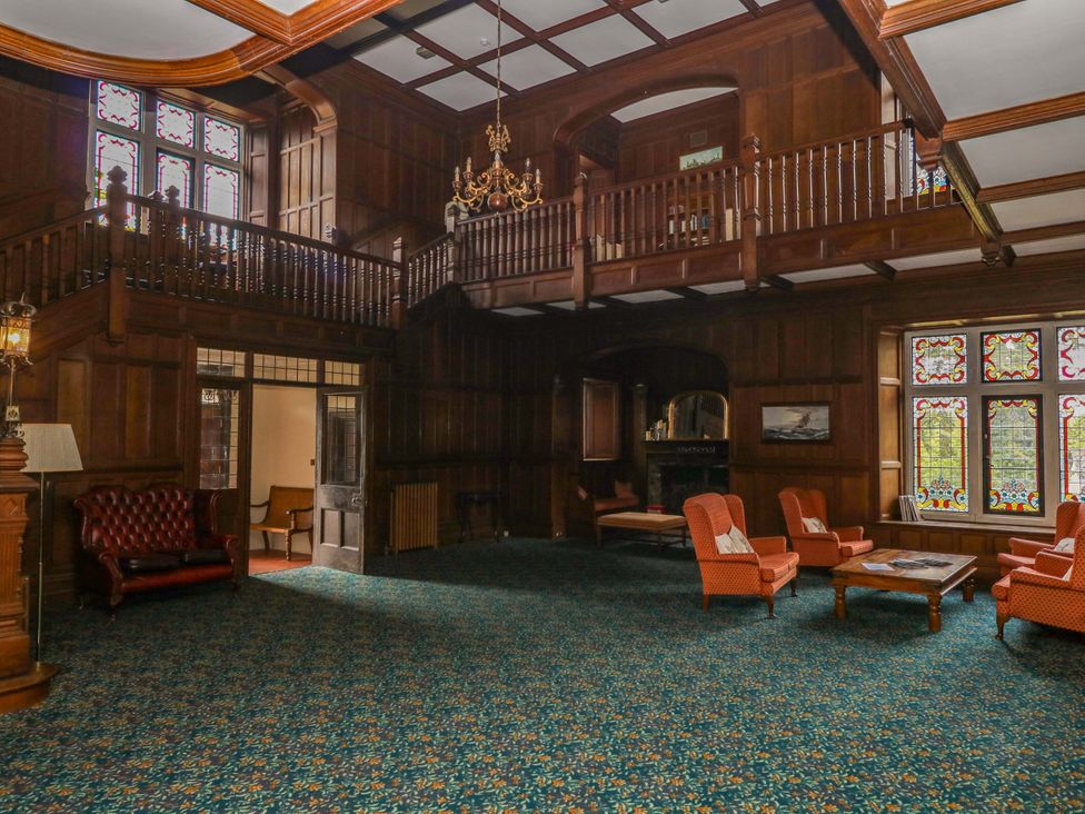 A living room with a fireplace and chairs at Alston Hall near Mothecombe Beach