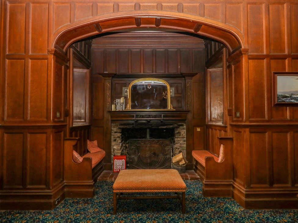 A sitting room with a fireplace and armchairs at Alston Hall near Mothecombe Beach