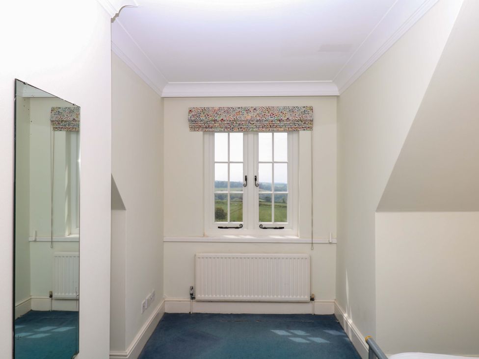 A bedroom with a window and a mirror at Alston Hall near Mothecombe Beach